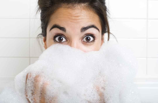 Femme avec du savon devant le visage